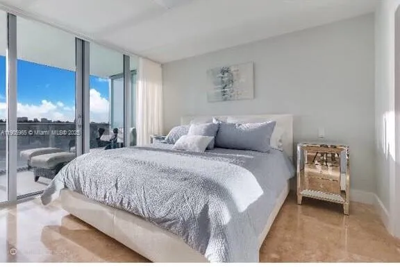 a spacious bedroom with a bed and a large window