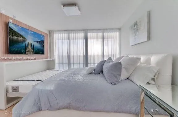 a bedroom with a large bed and a flat screen tv