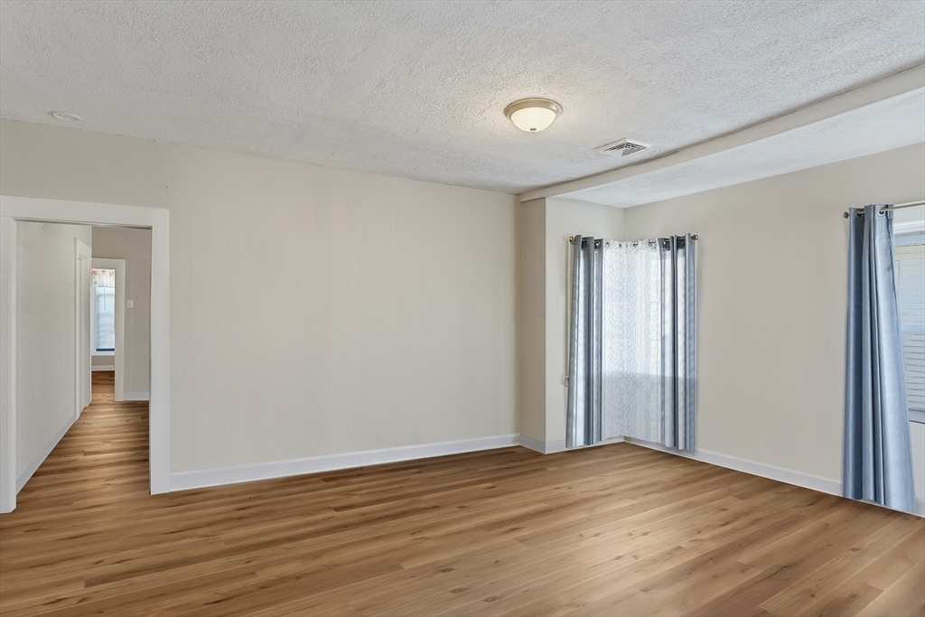 196 Irving Street Fall River, MA 02723 - Photo 26 of 34 a view of an empty room with wooden floor and a window
