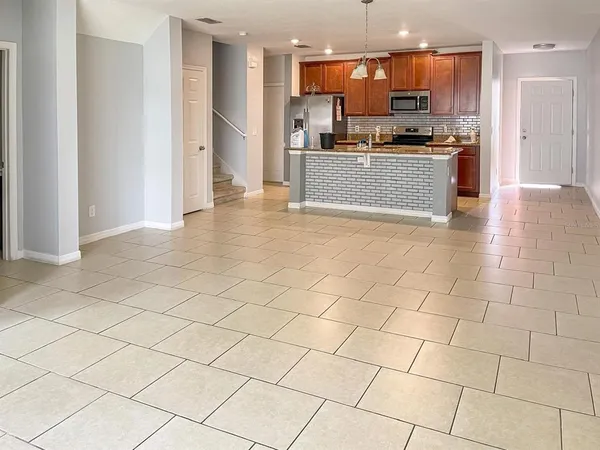 a large kitchen with stainless steel appliances kitchen island granite countertop a refrigerator and a stove top oven