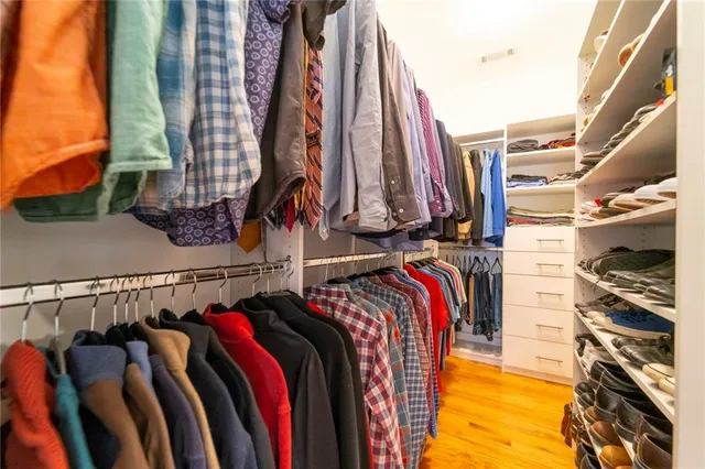 a bedroom with a large bed chandelier and a window