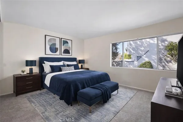 a bedroom with a bed and a large window