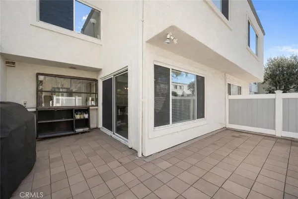 a view of an empty room with kitchen and window