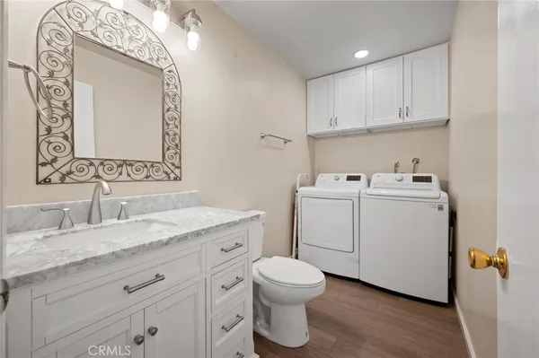 a bathroom with a granite countertop toilet sink and mirror