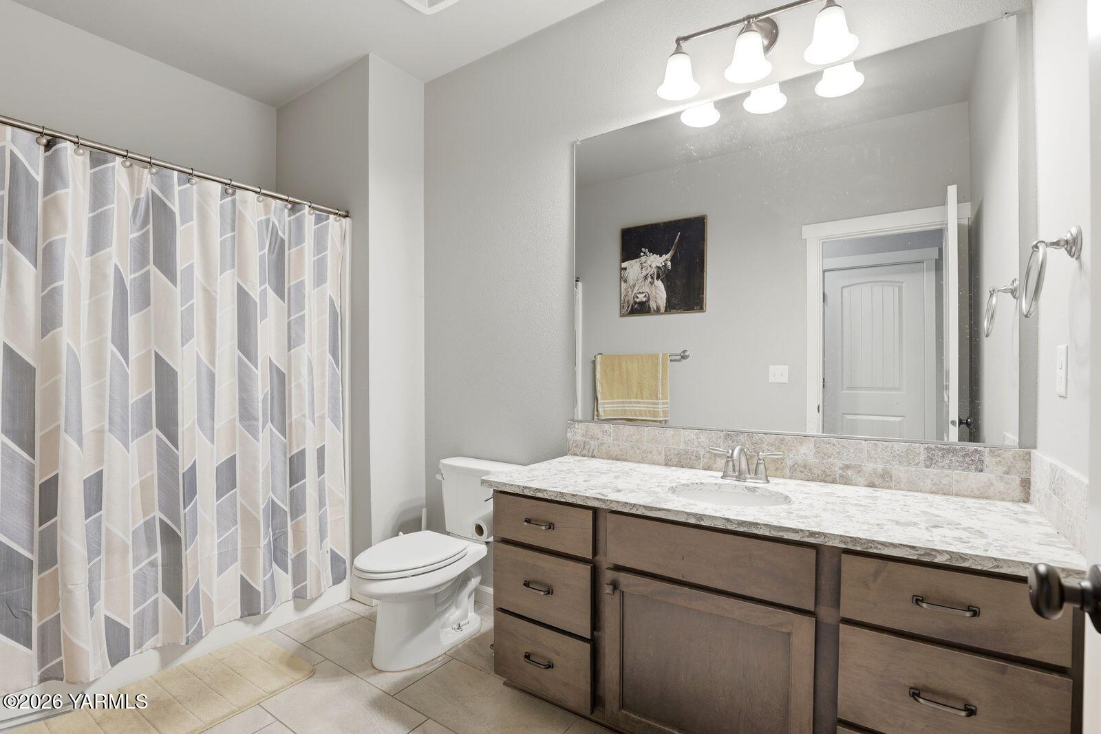 104 Bravo Street Moxee, WA 98936 - Photo 17 of 27 a bathroom with a granite countertop sink a toilet and a mirror