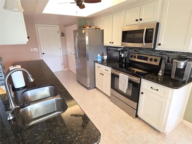 a kitchen with stainless steel appliances kitchen island granite countertop a stove a sink and a microwave