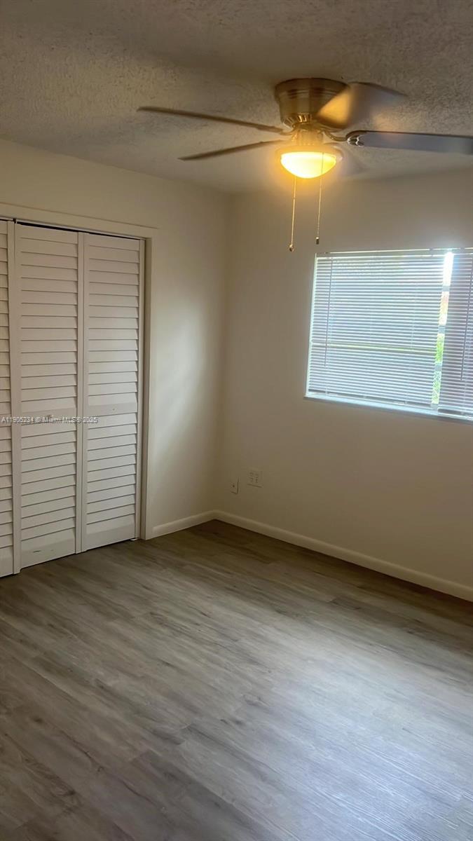 7230 Northwest 3rd Street, Unit 4 Miami, FL 33126 - Photo 7 of 13 an empty room with wooden floor and windows