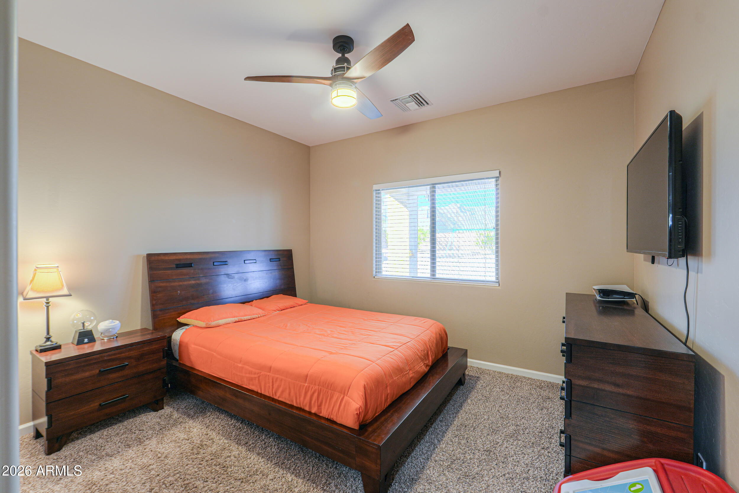 1487 South Mountain View Road Apache Junction, AZ 85119 - Photo 23 of 60 a bedroom with a bed and a flat tv screen on dresser