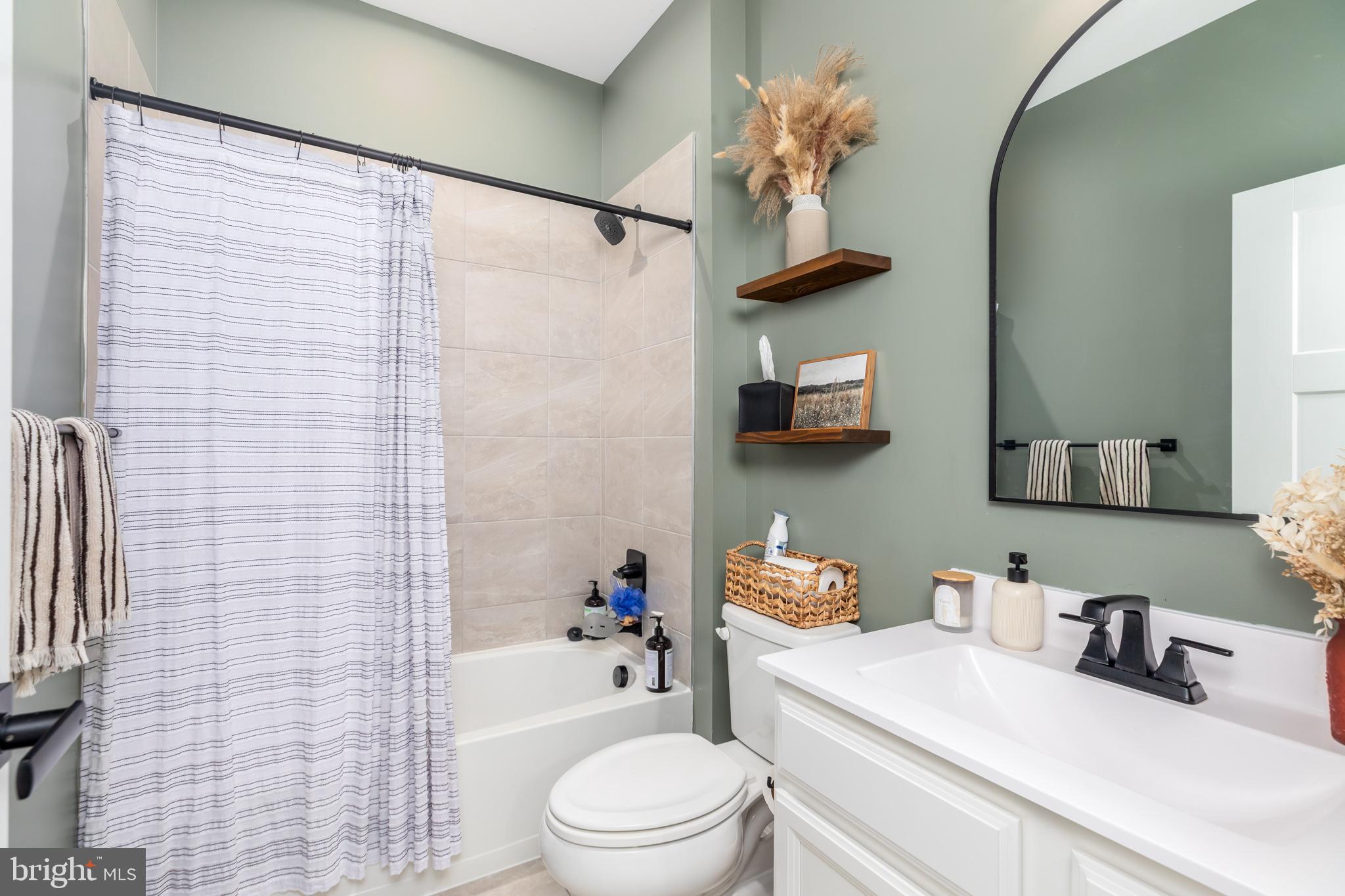 12125 Snug Harbor Road Berlin, MD 21811 - Photo 29 of 52 a bathroom with a sink a toilet and shower curtain