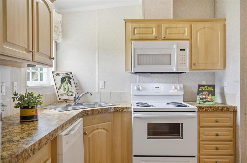 55716 Keith Street Astor, FL 32102 - Photo 13 of 32 a kitchen with stainless steel appliances white cabinets and a stove top oven