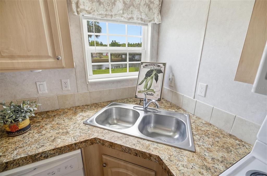 55716 Keith Street Astor, FL 32102 - Photo 14 of 32 a kitchen with granite countertop a sink and a window
