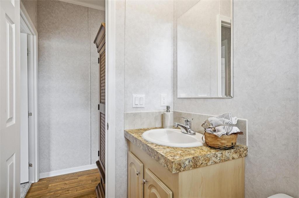 55716 Keith Street Astor, FL 32102 - Photo 27 of 32 a bathroom with a granite countertop sink and a mirror