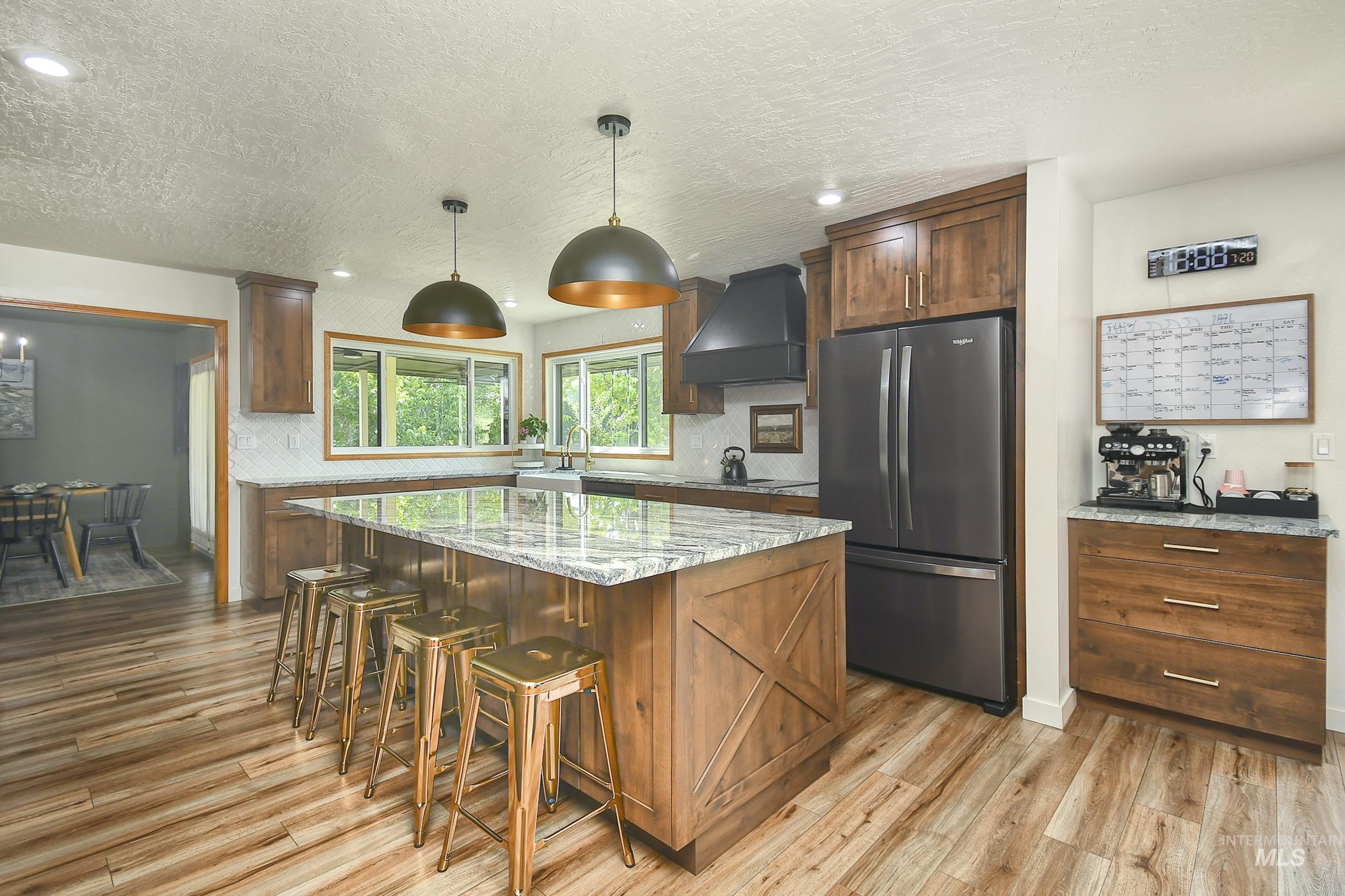 127 Ruth Lane Nampa, ID 83686 - Photo 15 of 49 Kitchen featuring a large wood-finish island with a stone countertop, built-in ovens, extensive wood-finish cabinetry, and recessed lighting