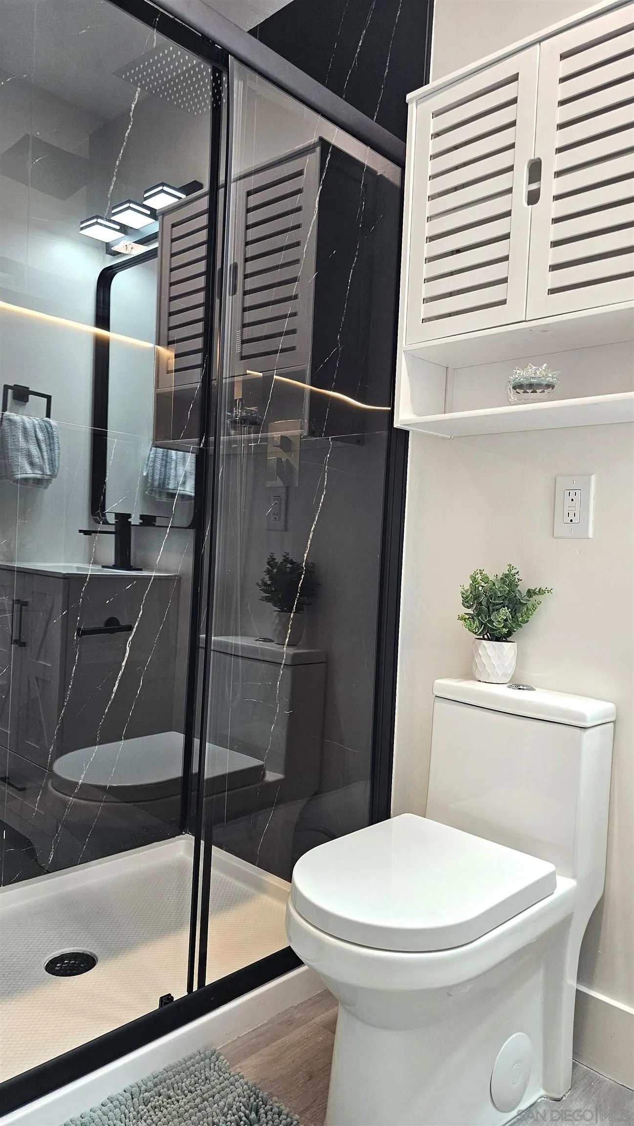 8667 Cetus Road San Diego, CA 92126 - Photo 16 of 22 a white toilet sitting next to a bathroom sink and a shower