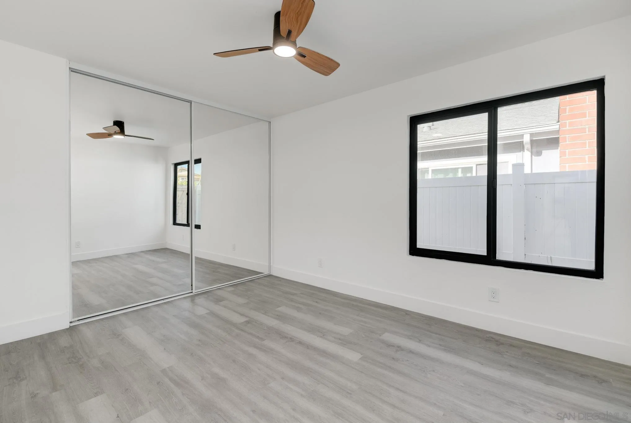 8667 Cetus Road San Diego, CA 92126 - Photo 19 of 22 a view of an empty room with window and chandelier fan