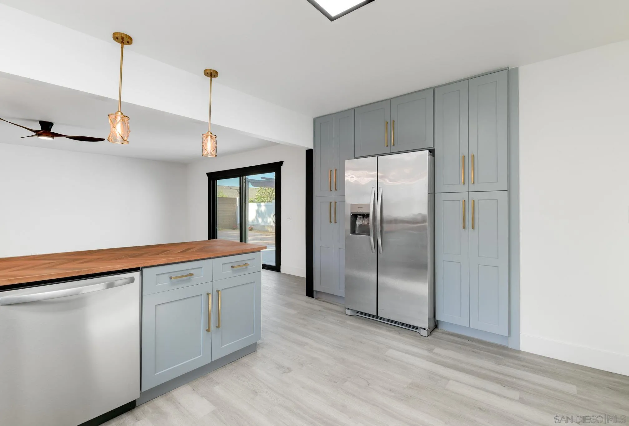 8667 Cetus Road San Diego, CA 92126 - Photo 5 of 22 a view of a kitchen with a sink refrigerator and wooden floor