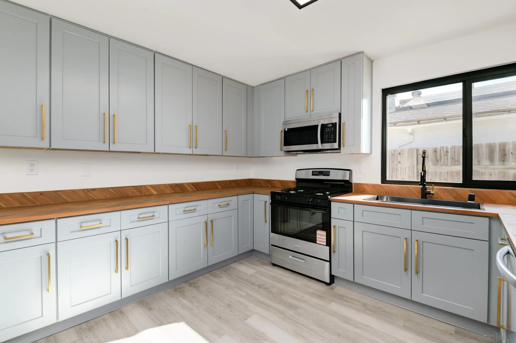 8667 Cetus Road San Diego, CA 92126 - Photo 6 of 22 a kitchen with cabinets stainless steel appliances and a window