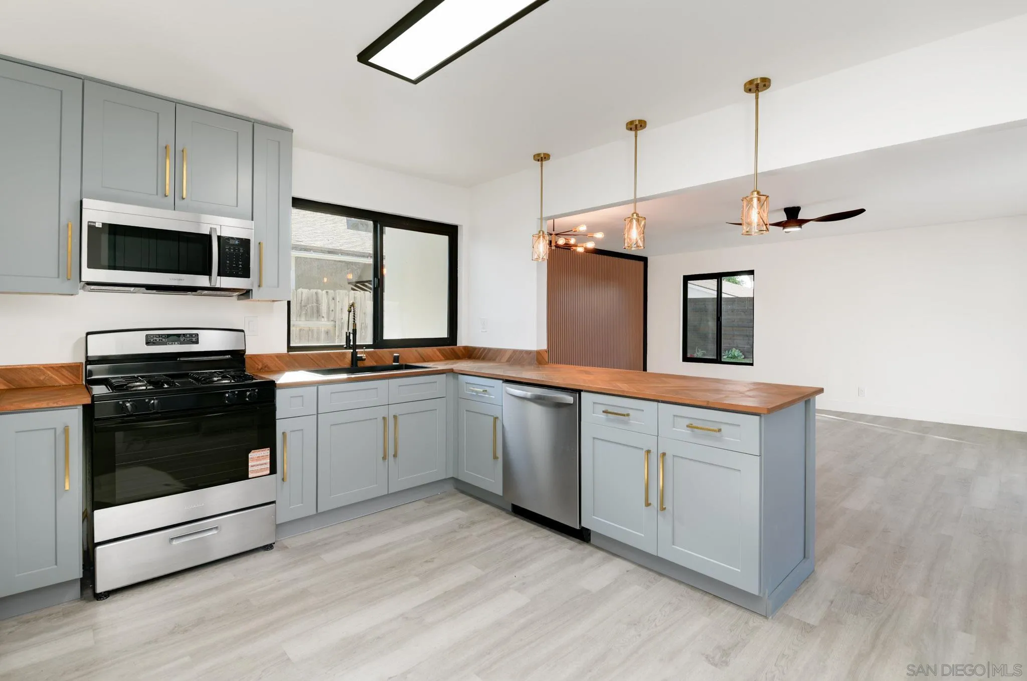 8667 Cetus Road San Diego, CA 92126 - Photo 7 of 22 a kitchen with a sink stove and microwave