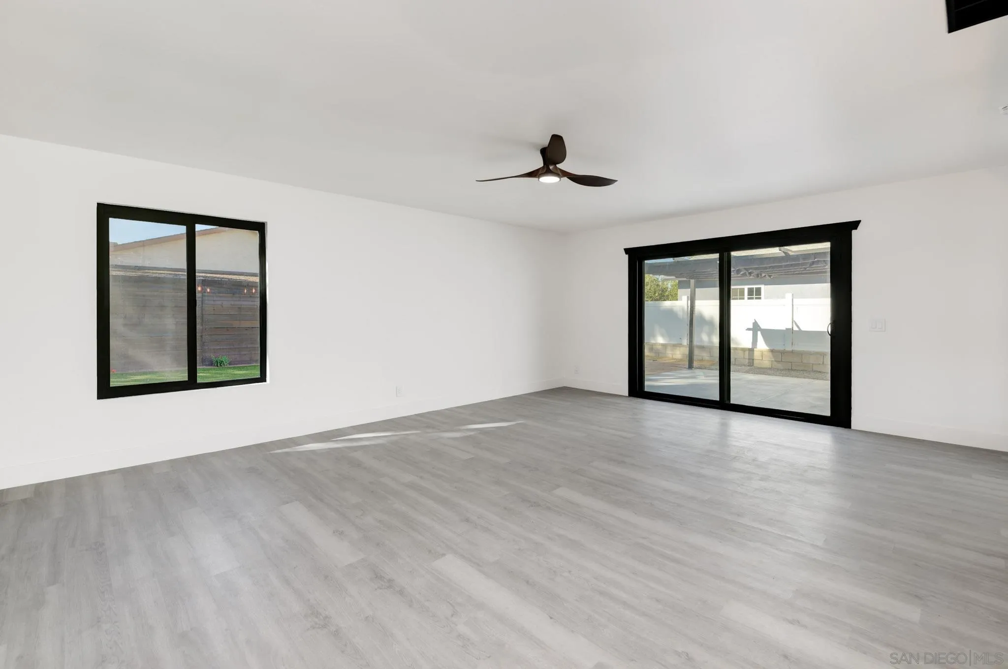 8667 Cetus Road San Diego, CA 92126 - Photo 8 of 22 a view of an empty room with a window and wooden floor