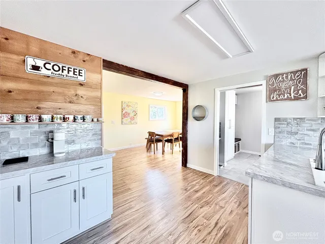 a dining room with wooden floor and large windows