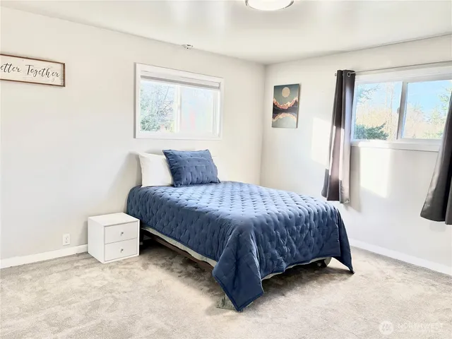 a bedroom with a bed and a painting on the wall