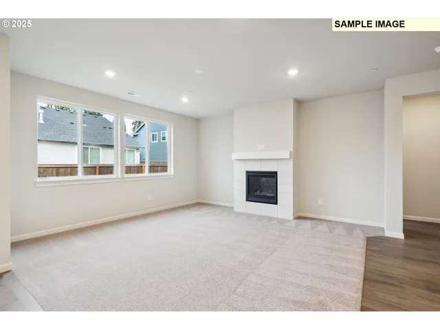 a view of an empty room with a window and fireplace