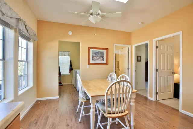 a kitchen with kitchen island a stove a sink a dining table and chairs