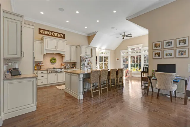 a kitchen with white cabinets and chairs
