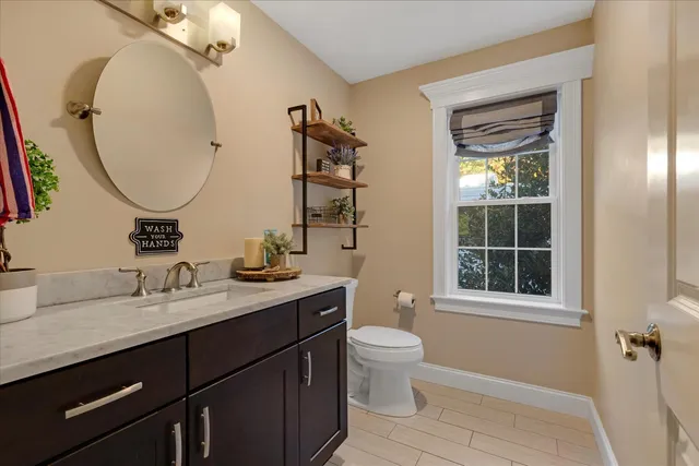 a bathroom with a granite countertop toilet sink and mirror