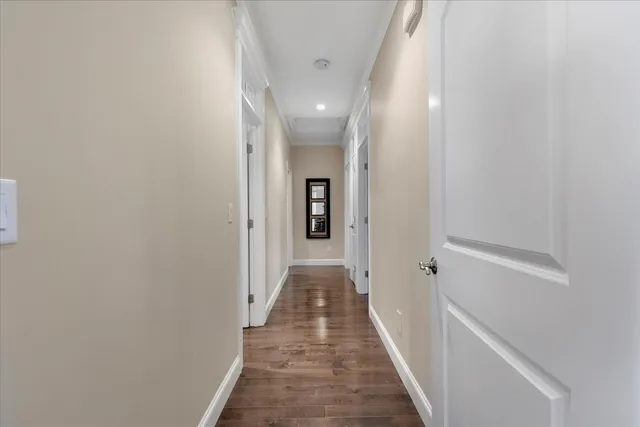a view of a hallway with wooden floor