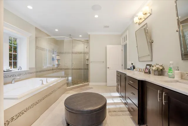 a spacious bathroom with a bathtub shower sink mirror and toilet