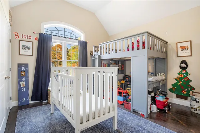a bedroom with baby crib and a window