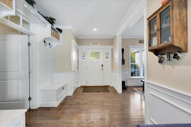 a view of a hallway with wooden floor and a living room