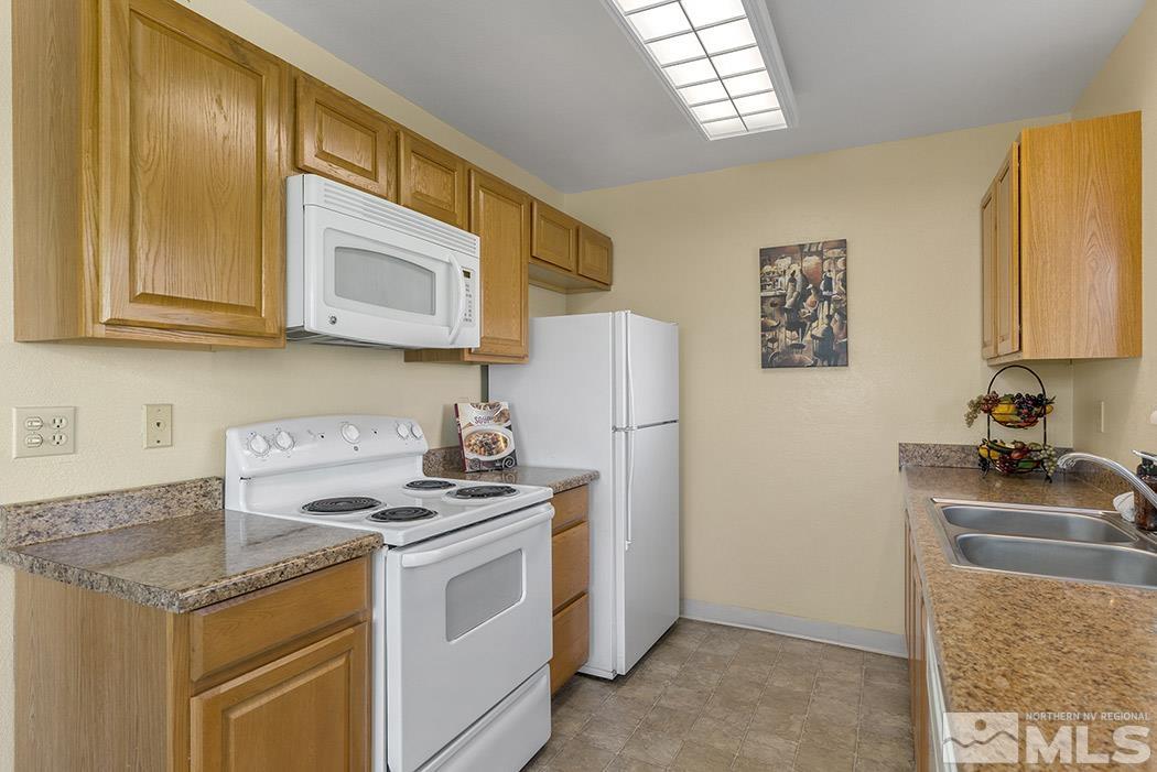 3943 Kings Row Reno, NV 89503 - Photo 12 of 16 a kitchen with stainless steel appliances granite countertop a stove a refrigerator and a microwave