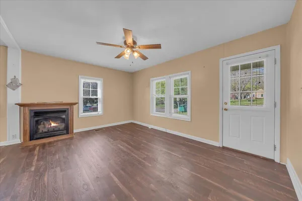 a view of empty room with wooden floor and fireplace