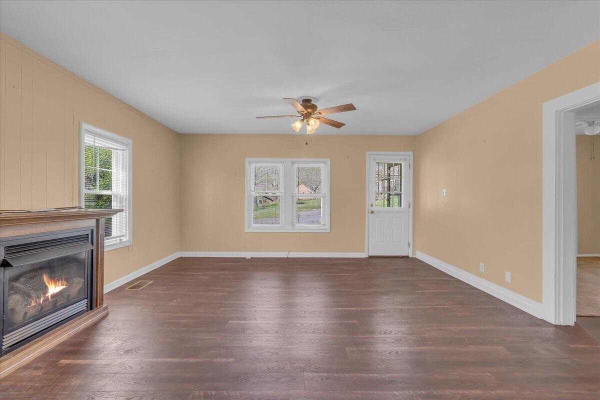 120 Raulstontown Road South Pittsburg, TN 37380 - Photo 7 of 22 a view of an empty room with wooden floor fireplace and a window