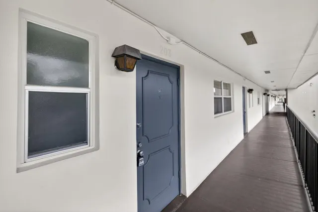 a hallway with wooden floor chandelier and entryway