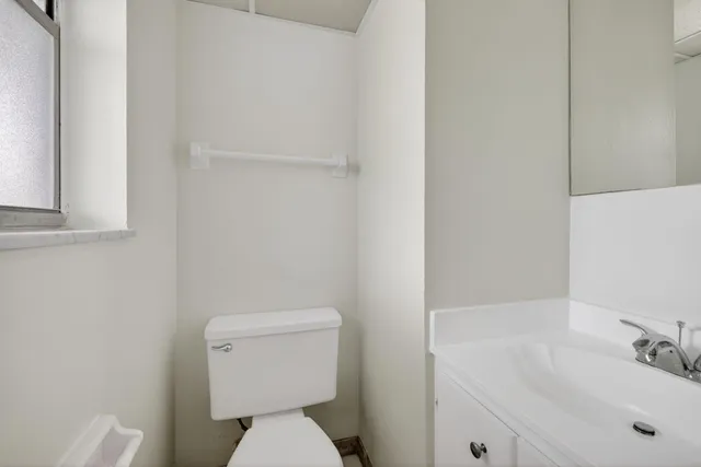 a bathroom with a sink a toilet and a mirror
