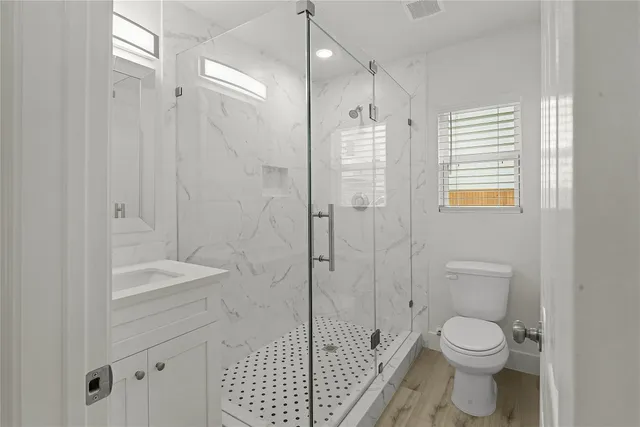 a bathroom with a sink a toilet and shower