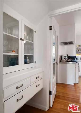 a view of kitchen island with cabinets and wooden floor