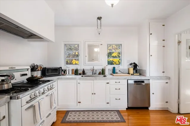 a kitchen with stainless steel appliances a white cabinets and sink