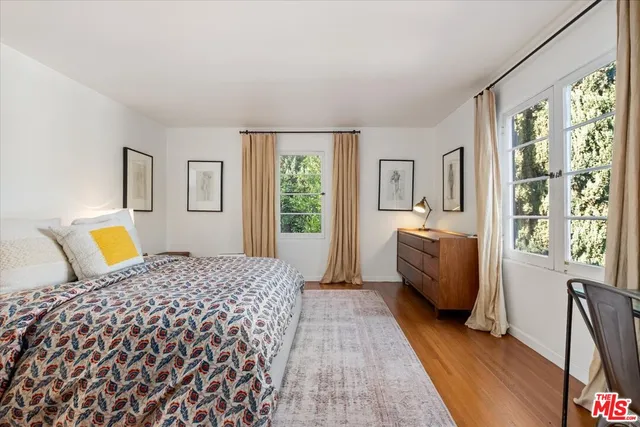 a bedroom with a bed couch and a large window