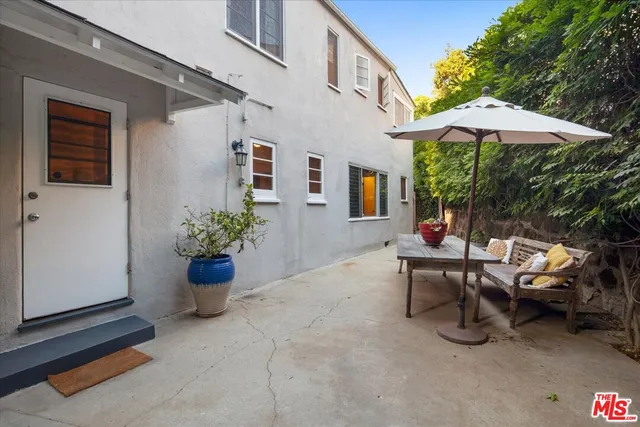 a view of a patio with couple of chairs and a potted plant