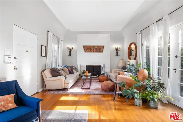 a living room with furniture fireplace and potted plants