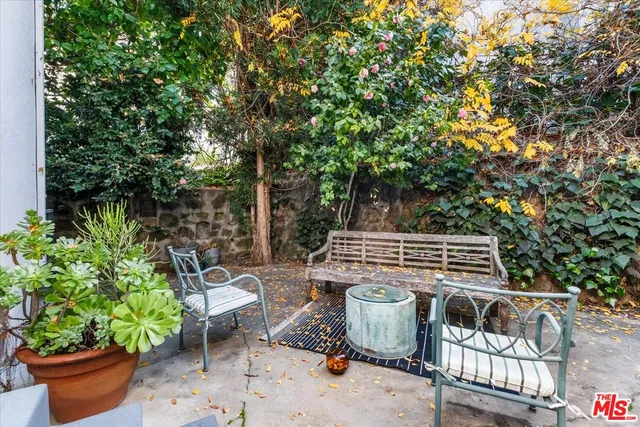 a view of a patio with chairs and potted plants