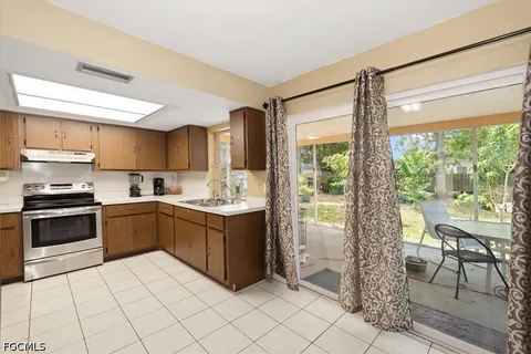 a kitchen with stainless steel appliances granite countertop a stove top oven a sink and a refrigerator