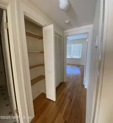 a view of a hallway with wooden floor
