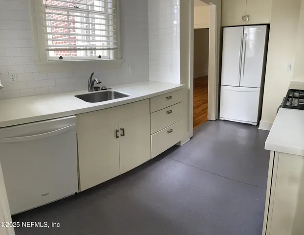 a kitchen with cabinets and a refrigerator