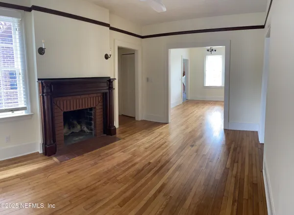 a view of a livingroom with wooden floor and a fireplace