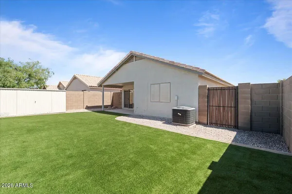 a view of a backyard with table and chairs and wooden fence